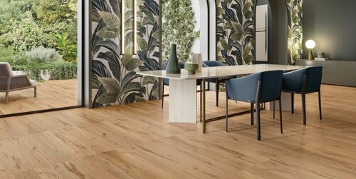 Der Holzboden aus feinstem Feinsteinzeug in Eichenoptik sorgt für ein warmes Ambiente im Esszimmer. Das grosse Wandbild mit grünen Blättern ist ebenso ein Hingucker aus Keramik.